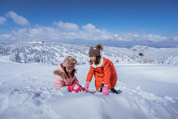 Fototapeta na wymiar two girl playing with snow. asian little sister enjoy their time in snowy winter together
