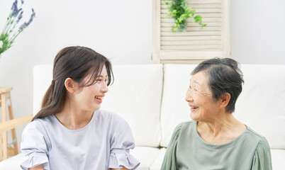自宅でノートパソコンを使う孫と祖母