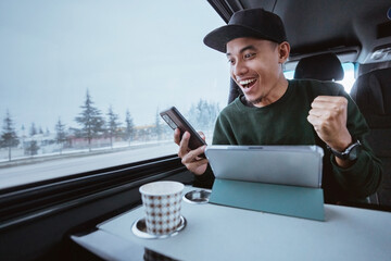 busy young man working while going out by a van. male business using mobile phone and tablet while traveling