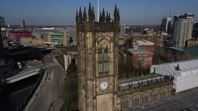 Aerial drone flight around Manchester Cathedral showing off its clocktower and stunning architecture