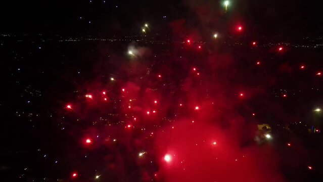 Slow motion drone shot close to sparkling fireworks exploding on the night sky