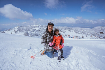 Fototapeta na wymiar happy father and daughter in the snow enjoying their time on top of the uludag mountain