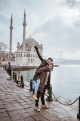 beautiful couple portrait smiling while visiting ortakoy mosque in turkey istanbul