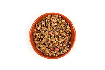 Whole dried sumac berries in a small red and black bowl over white top down