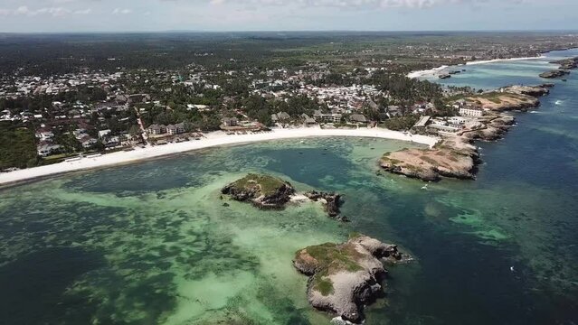 Beautiful drone shot of Watamu, Kenya. Long white sandy beach, resort and scenic coastal with rock formations.