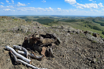 A place for a campfire surrounded by stones against the background of mountains on a summer day