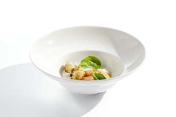 Gourmet dish - pan seared sea scallops with mashed potatoes, grilled cauliflowers on white plate. Scallops with vegetables and creamy espuma. Delicacy seafood in restaurant menu.