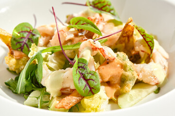 Green salad with broccoli, avocado, shrimps on white plate. Healthy dinner - Salad broccoli and prawns. Clean eating. Green bowl with vegetables and shrimps. Tempura broccoli with avocado, leaf, prawn