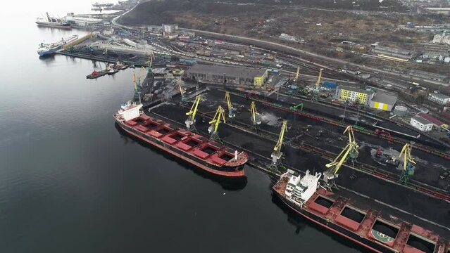 Flight over group of ships on berths of Murmansk seaport waiting for coal loading