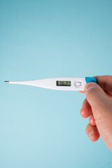 White digital thermometer on blue background 