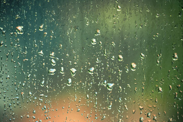 Raindrops on the glass looking out through the trees Urban and rural green leaves in cool, humid, fresh air, growing and relaxing.
