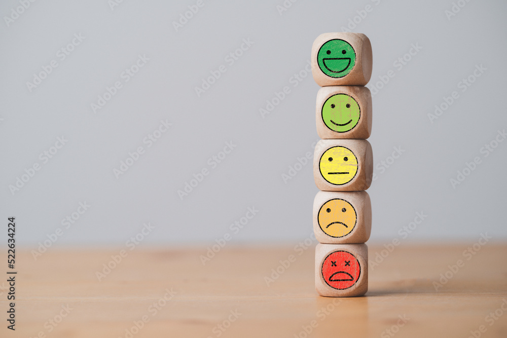 Poster Emotion icons stacking on wooden cube block include smile and sad emotion for customer service evaluation concept.