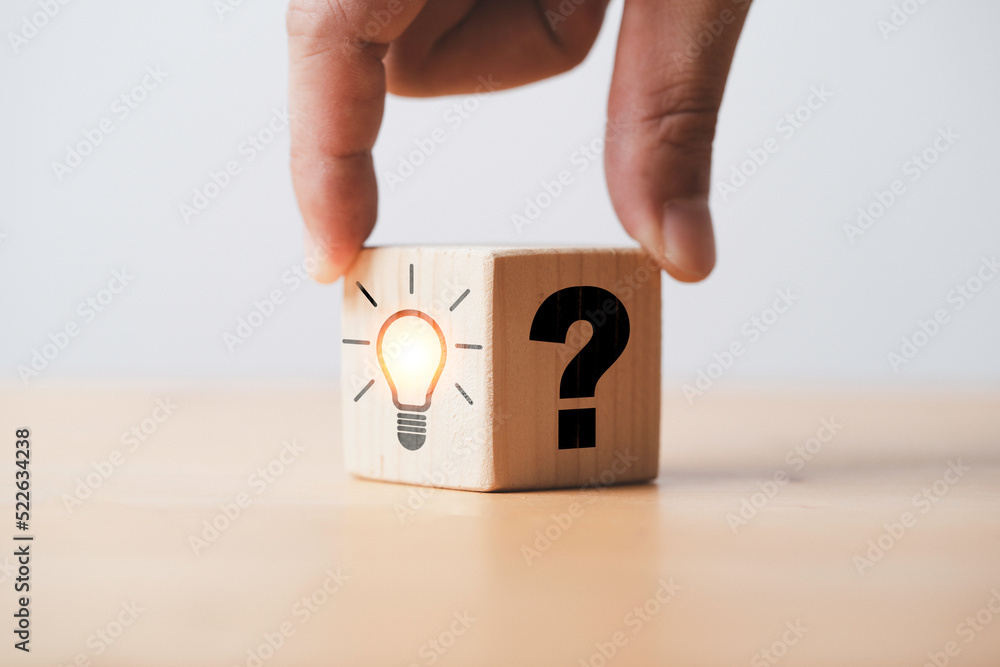 Poster hand flipping between question mark and glowing lightbulb for question and answer of problem solutio