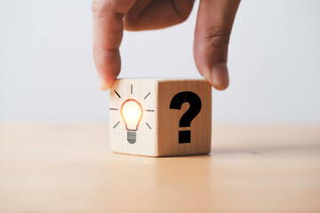 Hand flipping between question mark and glowing lightbulb for question and answer of problem...