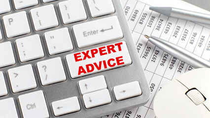 EXPERT ADVICE text on a keyboard wirh chart and pencil