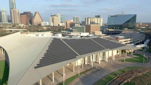 Solar Panels on roof in Austin Texas, Clean solar energy urban commercial installation, aerial drone video 4k