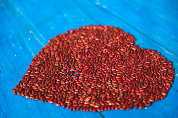 Heart Made out of Red Dried beans on Blue Table Close up