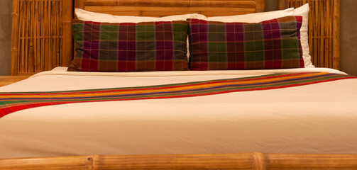 colorful pillows on white mattress in bamboo bed