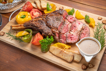 Barbecue Tomahawk Steak on wooden plate.Grilled tomahawk ribeye steak with baked potatoes...