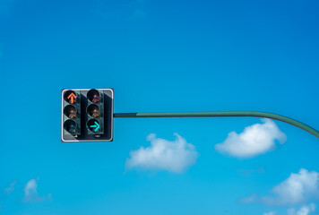 Traffic lights against a vibrant blue sky. Front direction is red, and side direction is green