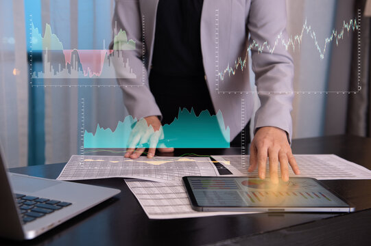 businesswomen using digital tablet for analysis investment portfolio in stock market with index stock market and chart with uptrend stock market graph.