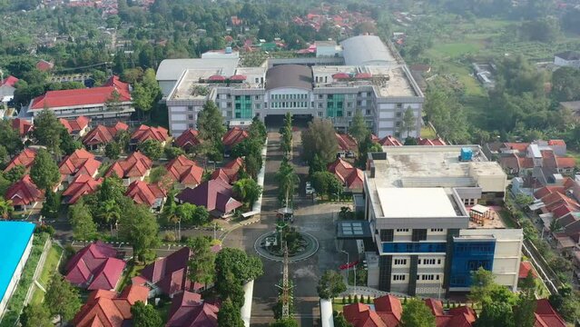large university campus surrounded by Indonesian homes in Bandung at sunrise, aerial