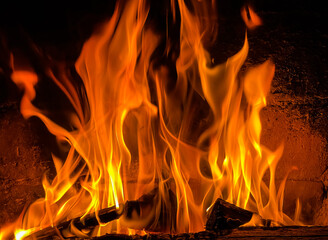 Flames of fire and hot coals of burned wood in the fireplace