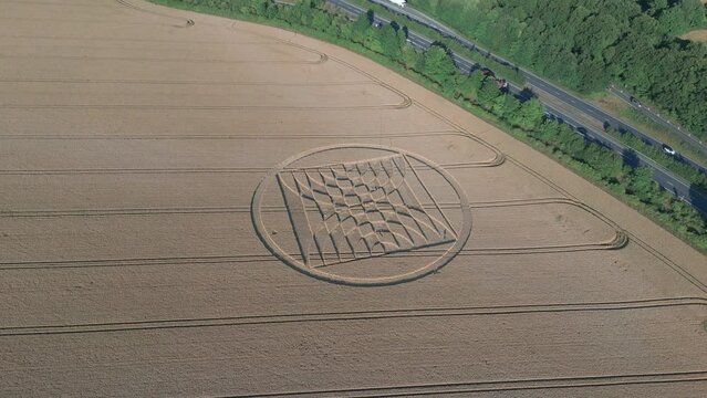 Aerial View Of Traffic Passing By Crop Circle In Micheldever Station, England.