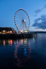 Ferris wheel reflecting in water at night