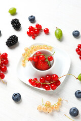 Concept of fresh food on white wooden background, berries