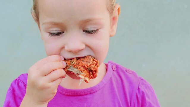close up portrait of a pretty little girl eating fried chicken hungry kid meat