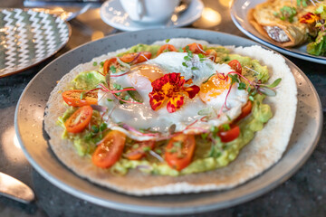 Avocado con casabe, tomate y especies verdes, toma cerrada de comida de alta mesa.