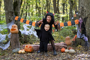 Halloween. Mother with little son in halloween costumes having fun outdoor