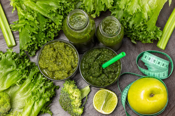 Obraz premium Green smoothie in glasses and bottles. Measuring tape around an apple.