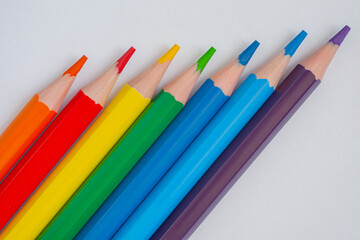 Many different colored pencils on white surface, background - top view, close up. Abstract,...