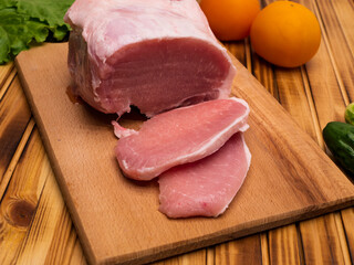 Tasty raw veal or beef meat on wooden cutting board. Preparing for frying.