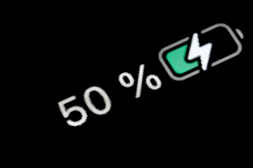 Smartphone battery level indicator charging process - white pixel number - fifty, 50 percent: close...