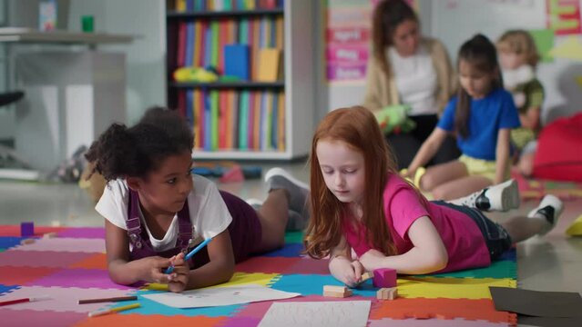 Cute primary school age girls of mixed race studying together. 
