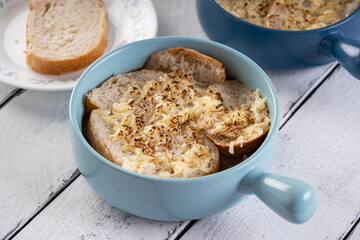 a bowl of hot French onion soup with mozzarella cheese and french bed on top