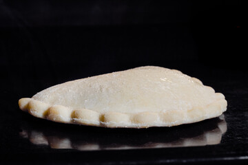 Uncooked shortcrust pastry pie, flat cake with cottage cheese baking on tray in electric oven, black background - close up. Cooking, food, homemade bakery and semi-finished products concept