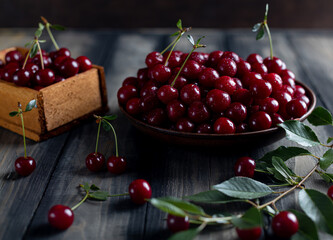 ripe cherries in a plate on a wooden table
