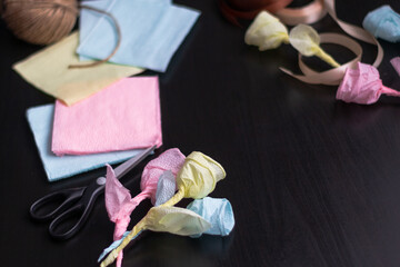 Multicolored roses made by hand from napkins on a black background