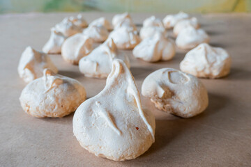Homemade french milk-colored meringues on crumpled craft paper