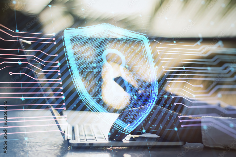 Poster close up of businessman hands using laptop and smartphone on desktop and creative glowing shield cir