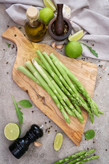 Green organic natural Asparagus on wooden cutting board at kitchen table
