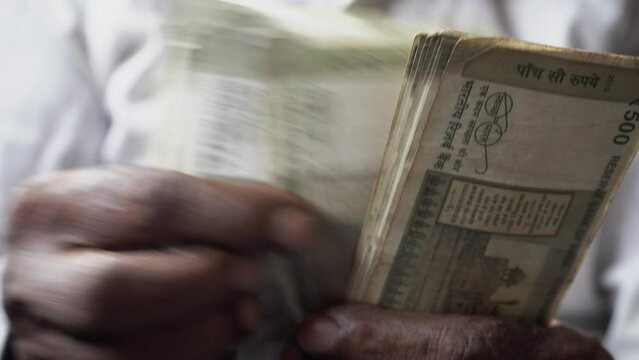 Closeup of a hand counting Indian currency notes, Mumbai, India