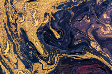 Luxury fluid art painting background. Spilled purple, blue and gold acrylic paint.  Liquid marble pattern. Alcohol ink splash.