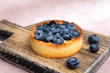 Blueberry pie on a wooden board. Blueberry tart. Berry dessert on a wooden background.