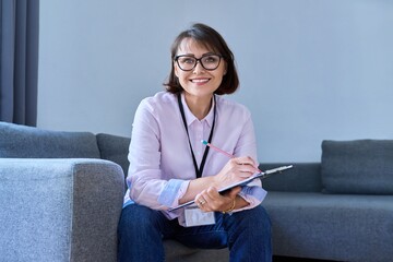 Portrait of female psychologist sitting on sofa in office