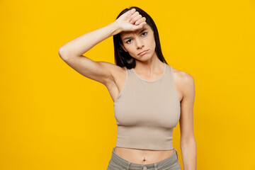 Obraz premium Young sad sick tired exhausted latin woman 30s she wear basic beige tank shirt put hand on forehead suffer from headache isolated on plain yellow backround studio portrait People lifestyle concept.